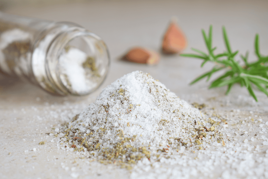 Frisch gemachtes Kräutersalz mit frischem Rosmarin im Hintergrund