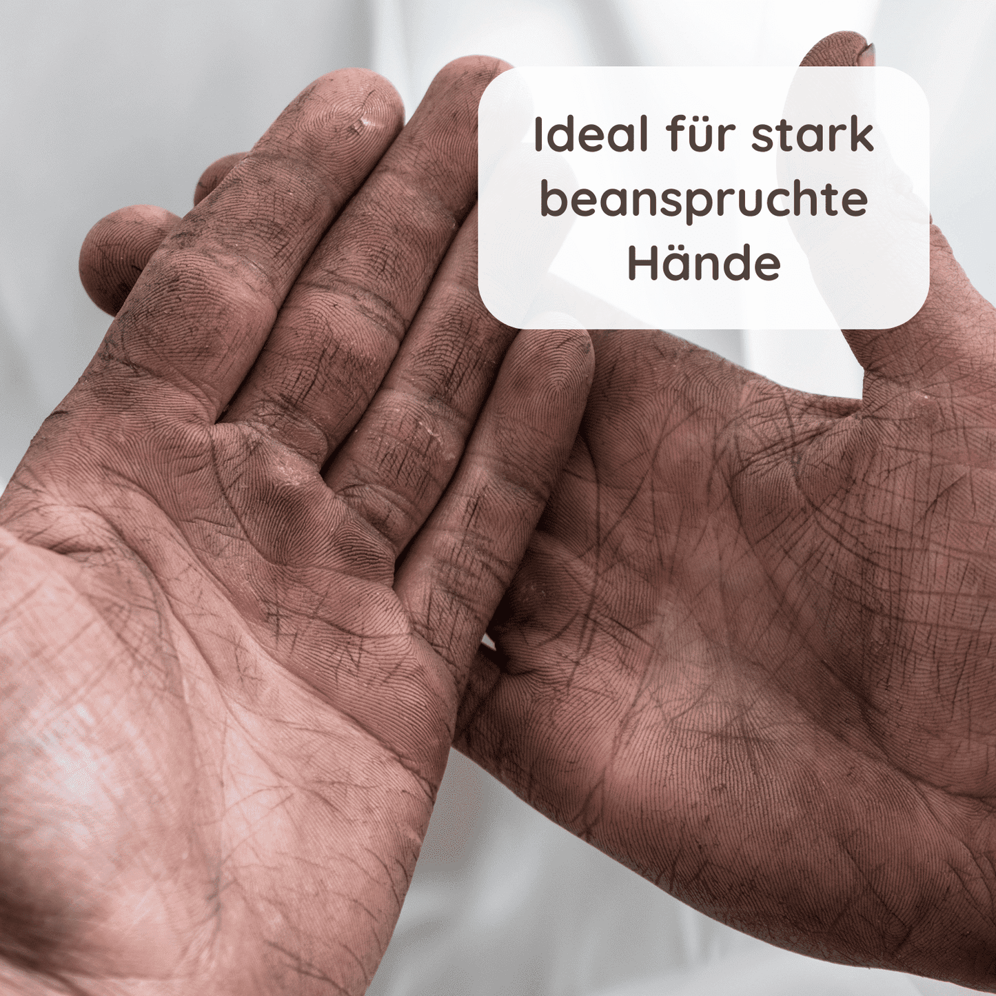 “Ein Paar stark beanspruchte Hände mit sichtbaren Schmutzspuren und Rissen. Darüber steht in einem weißen Textfeld: ‘Ideal für stark beanspruchte Hände’.”