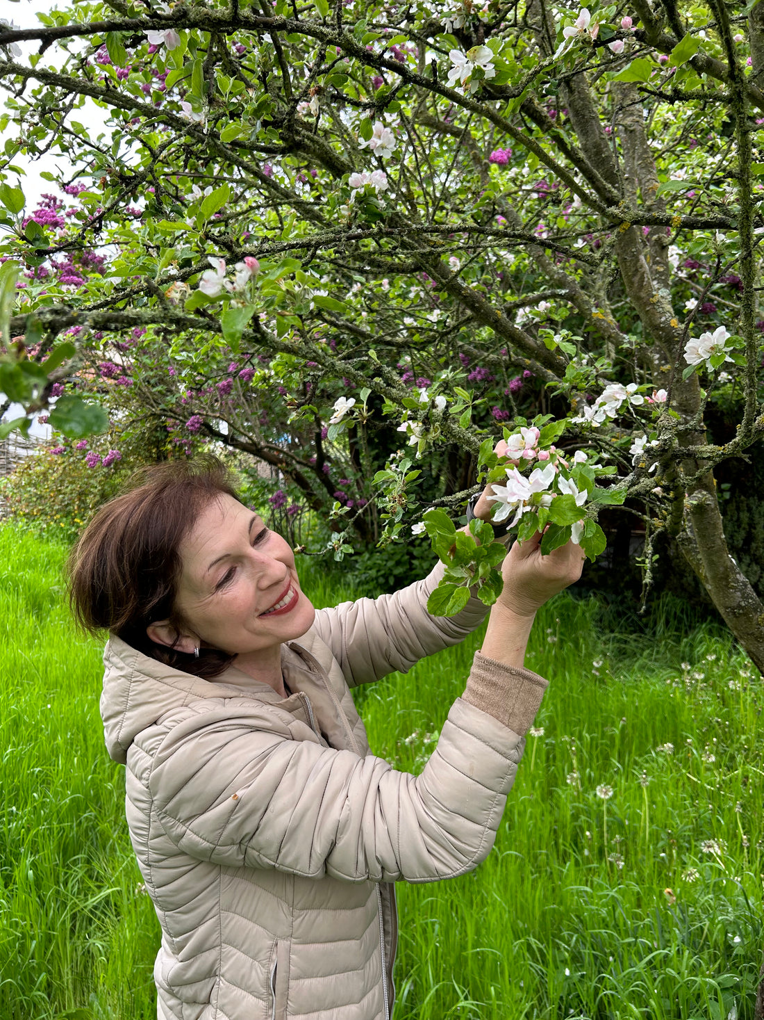 Anja Heinz im Garten neben einem Apfelbaum