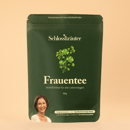 Frauentee mit Frauenmantel und Melisse in grünem Beutel auf beigem Hintergrund