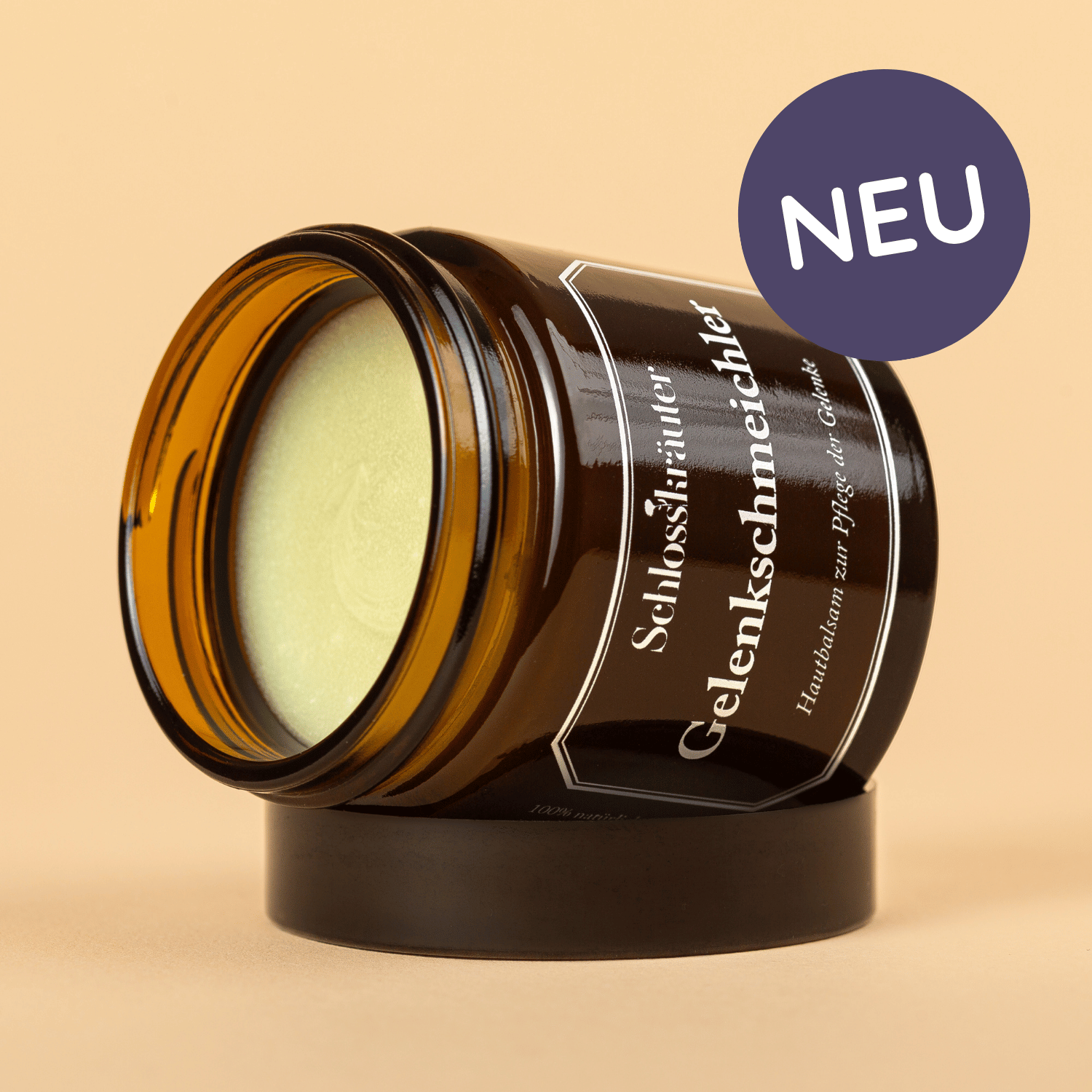 Braunes Glas mit grünlicher Salbe für die Hautpflege bei Gelenkbeschwerden auf beigem Hintergrund mit Auschrift "NEU"