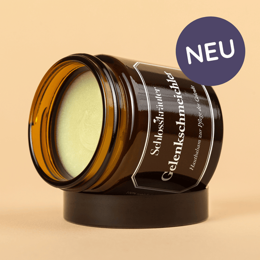 Braunes Glas mit grünlicher Salbe für die Hautpflege bei Gelenkbeschwerden auf beigem Hintergrund mit Auschrift "NEU"